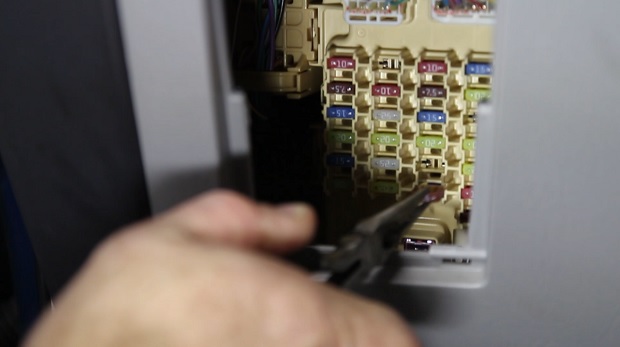 image: pulling a fuse out of a fuse box