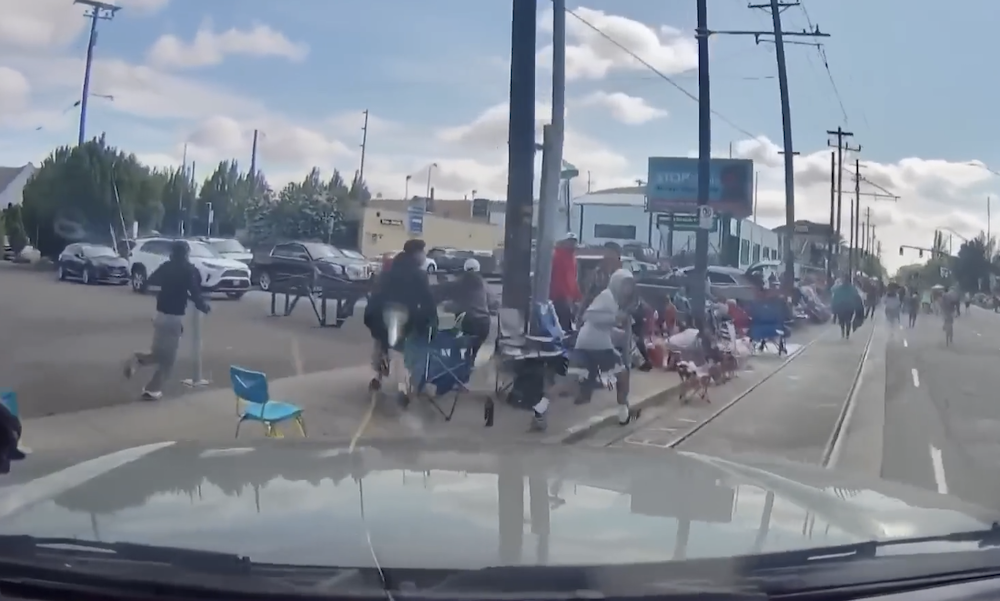 Dashcam Screen Grab Of A Group Of Spectators Running Away As Truck Almost Hits Them
