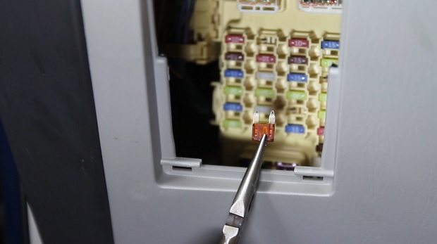 image: pulling a fuse out of a fuse box